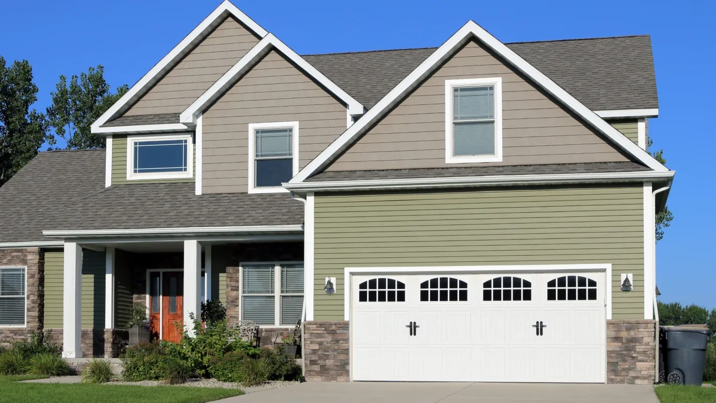 A home with gray and green siding that has white trim