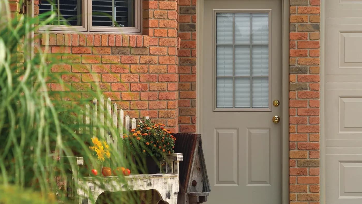 A brown door in a brick home